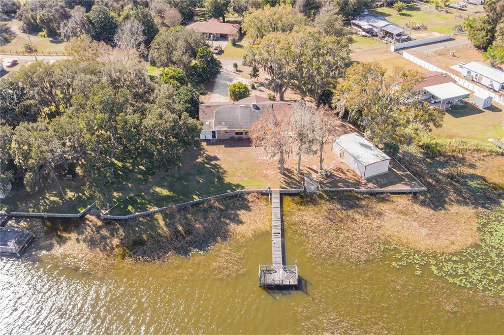 An aerial view shows a house with a dock extending into a lake — 436 JEFFERY LANE, HAINES CITY, FL