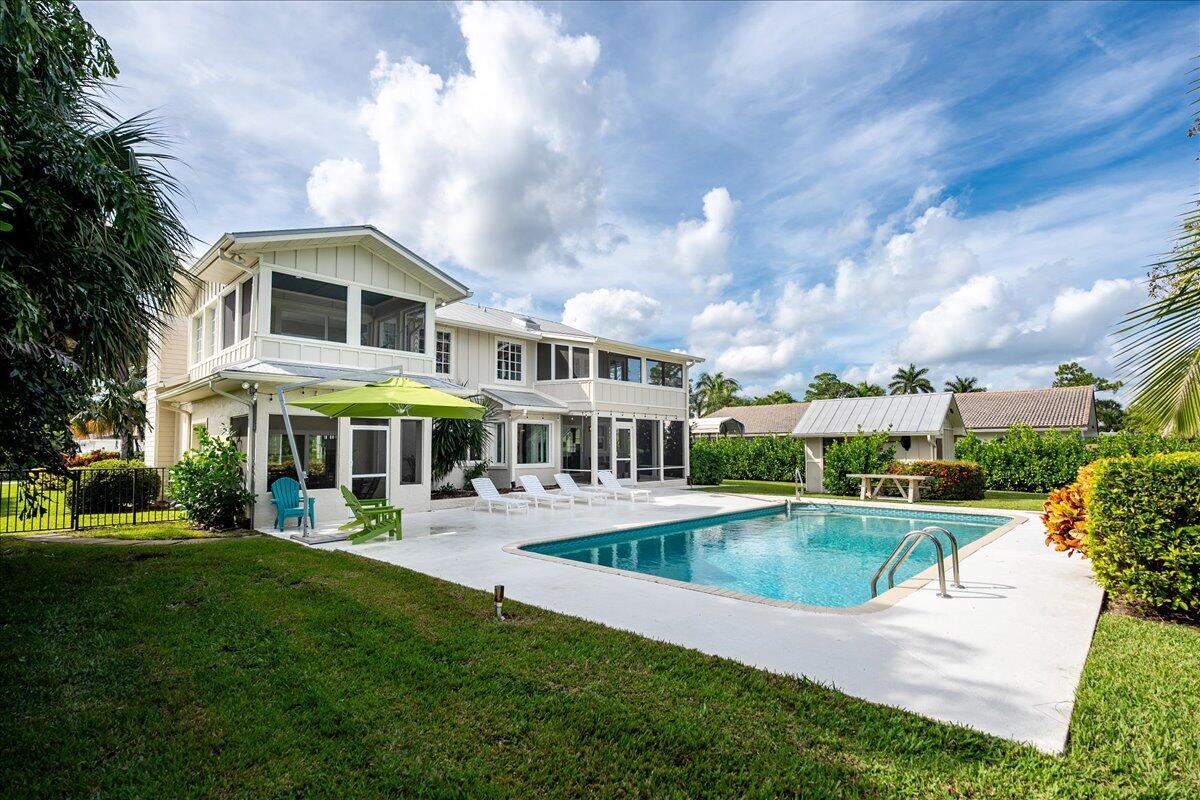 A two-story house with a white exterior, a swimming pool, and a patio area — 1947 NW Palmetto Terrace, Stuart FL 34994, STUART, FL