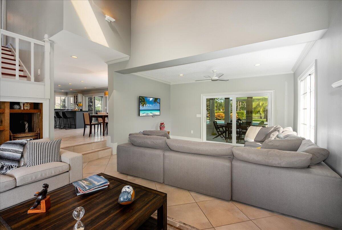 A living room with a large sectional sofa, a coffee table, and a view into the kitchen — 1947 NW Palmetto Terrace, Stuart FL 34994, STUART, FL