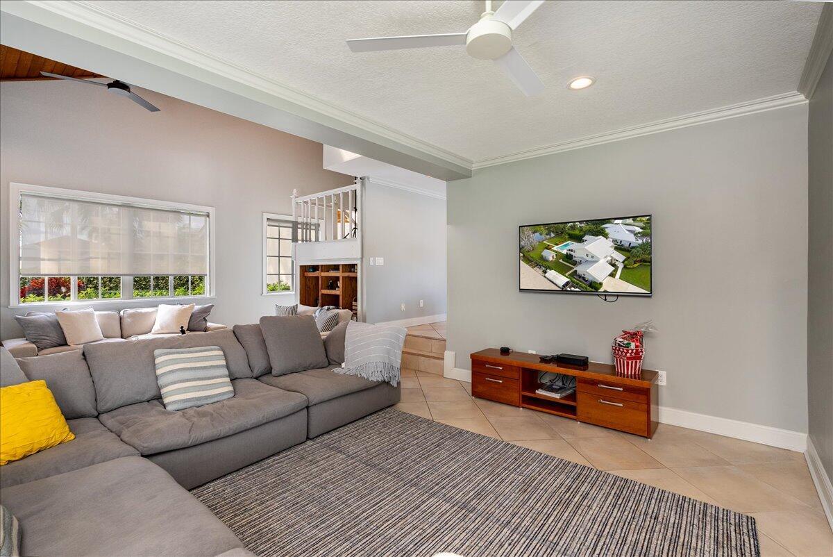 A living room features a large gray sectional sofa, a television, and a wooden media console — 1947 NW Palmetto Terrace, Stuart FL 34994, STUART, FL