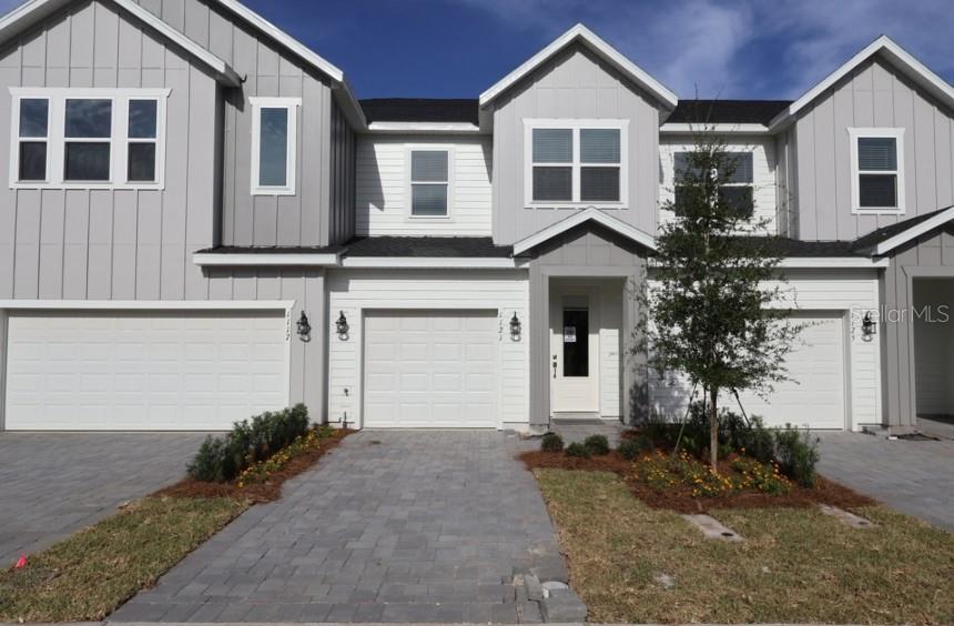 A modern kitchen features light gray cabinets, a white island, and tile flooring — 1121 WILD CREST LANE, DAYTONA BEACH, FL