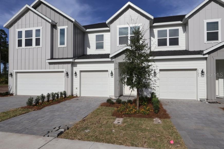 A modern kitchen features white cabinetry, stainless steel appliances, and a large central island — 1121 WILD CREST LANE, DAYTONA BEACH, FL