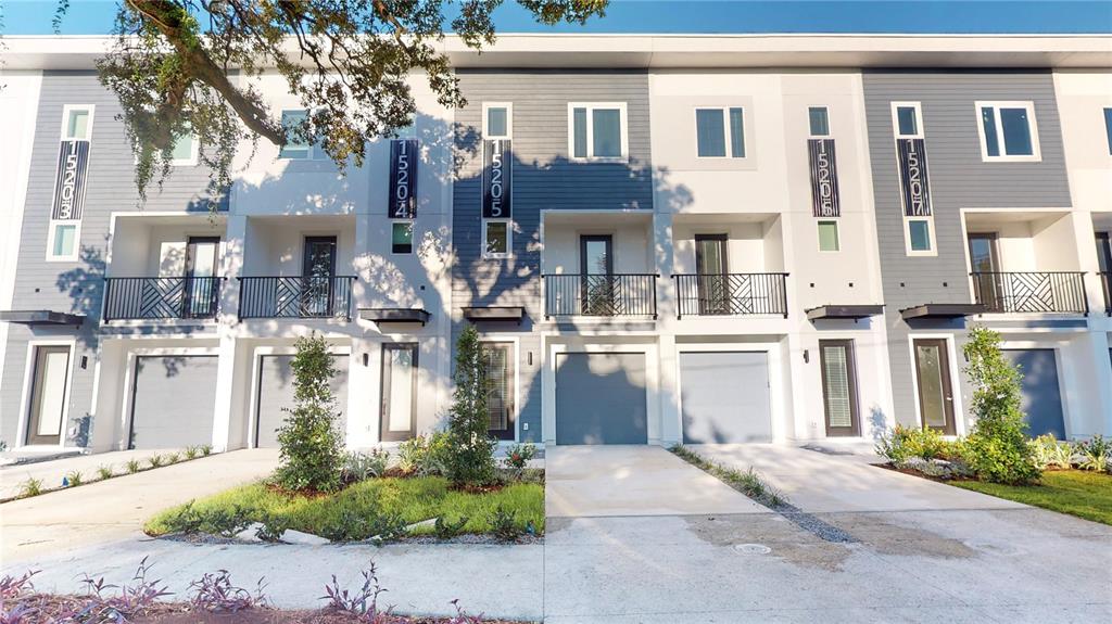 A row of modern townhomes features gray and white siding, balconies, and attached garages — 1520 N PIERCE STREET UNIT 5, TAMPA, FL