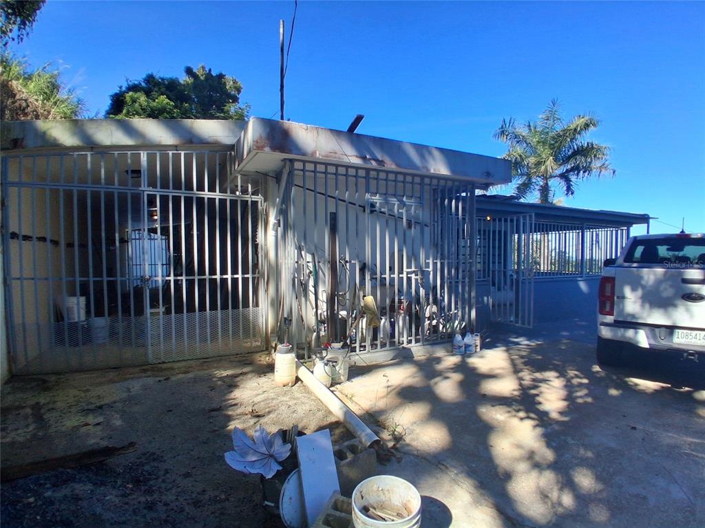 A white truck is parked in front of a house with a gated carport area — 842 km 8.3 CAIMITO ALTO ST,SECTOR CAMINO PABLO DIAZ, SAN JUAN, PR