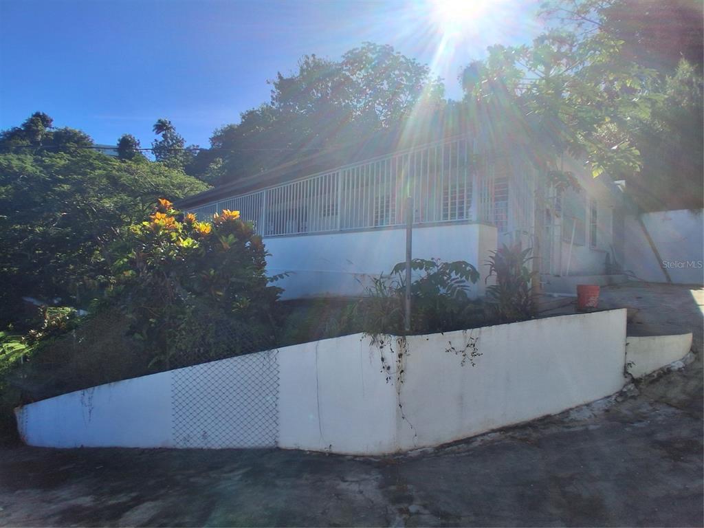 A single-story house with a white exterior, a fenced porch, and a concrete retaining wall — 842 km 8.3 CAIMITO ALTO ST,SECTOR CAMINO PABLO DIAZ, SAN JUAN, PR