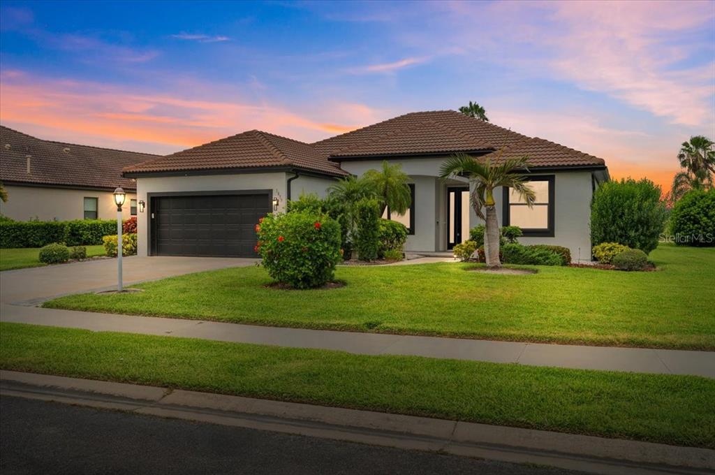 A single-story house with a tile roof, two-car garage, and a landscaped front yard — 1835 BOBCAT TRAIL, NORTH PORT, FL