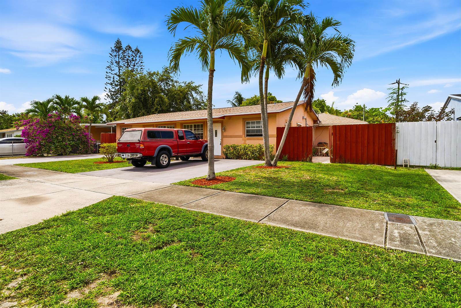 A single-story peach-colored house features a red pickup truck parked in the driveway — 550 NE 37th Street # 2, Pompano Beach FL 33064, POMPANO BEACH, FL