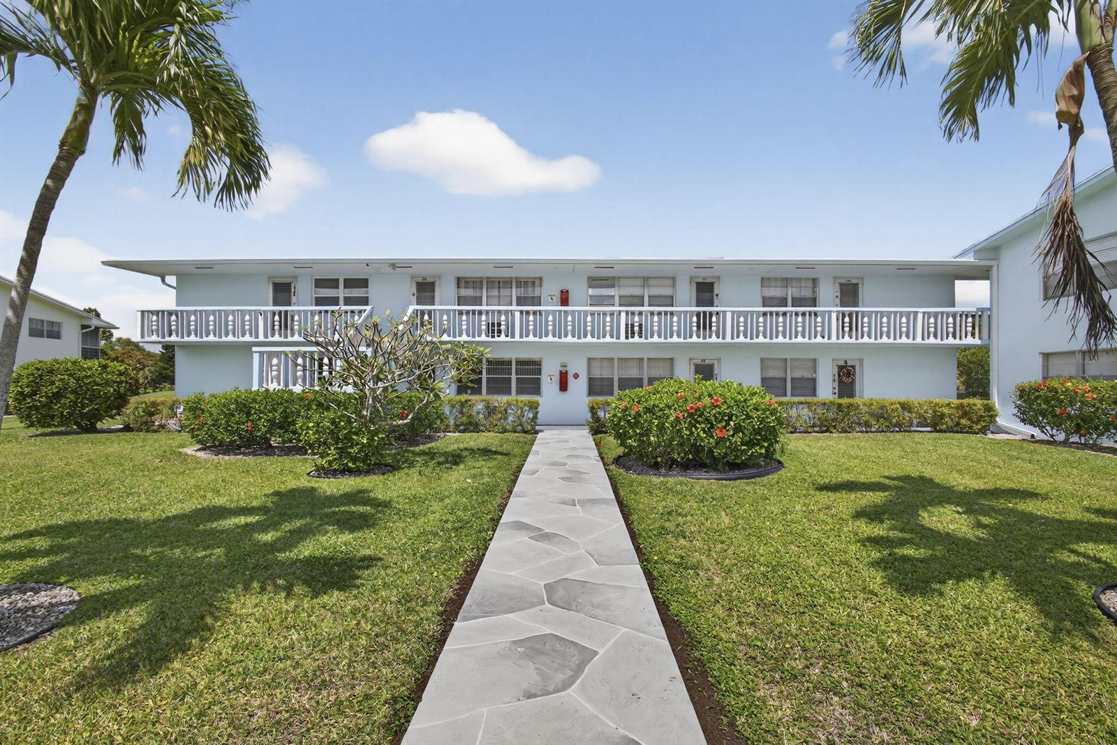 A two-story apartment building with a stone walkway leading to the entrance — 106 E Camden E, West Palm Beach FL 33417, WEST PALM BEACH, FL