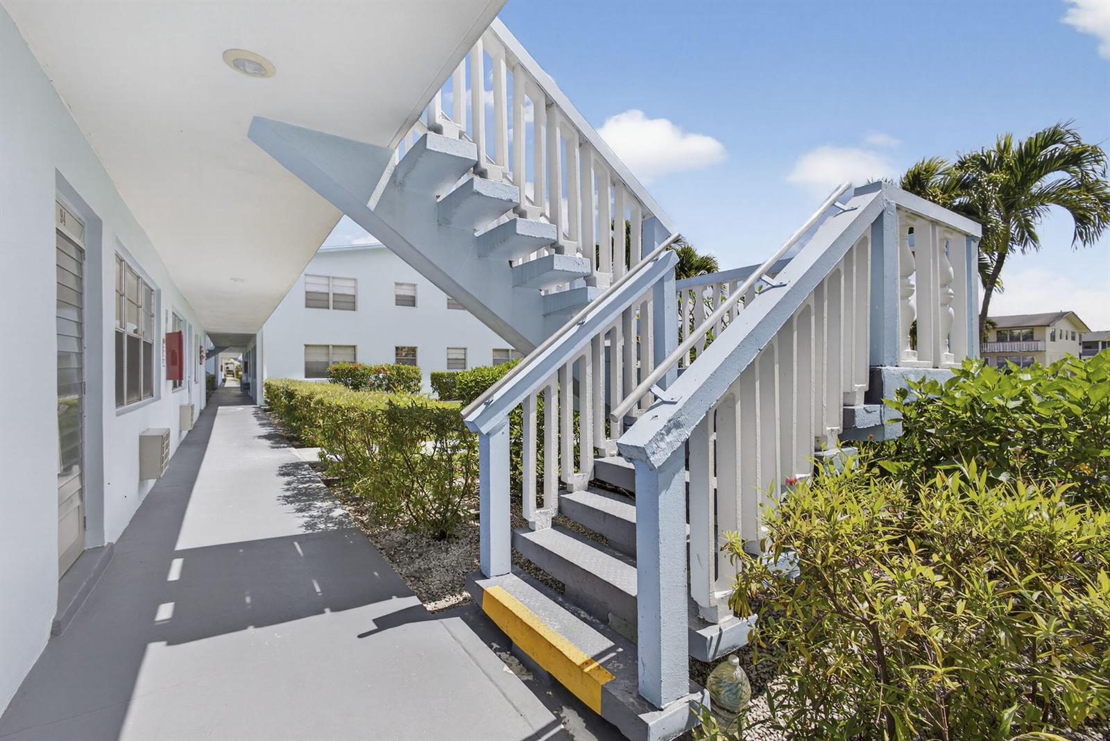 An outdoor concrete staircase with white railings leads to an upper level walkway — 106 E Camden E, West Palm Beach FL 33417, WEST PALM BEACH, FL