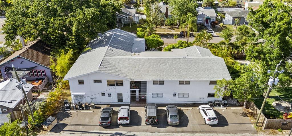 An aerial view shows a white two-story apartment building with a parking lot — 3036 6TH AVENUE N, ST PETERSBURG, FL