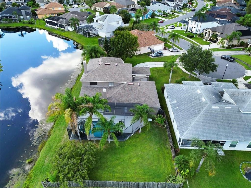 An aerial view shows a house with a screened pool deck beside a lake — 14024 CHERRY BUSH COURT, ORLANDO, FL