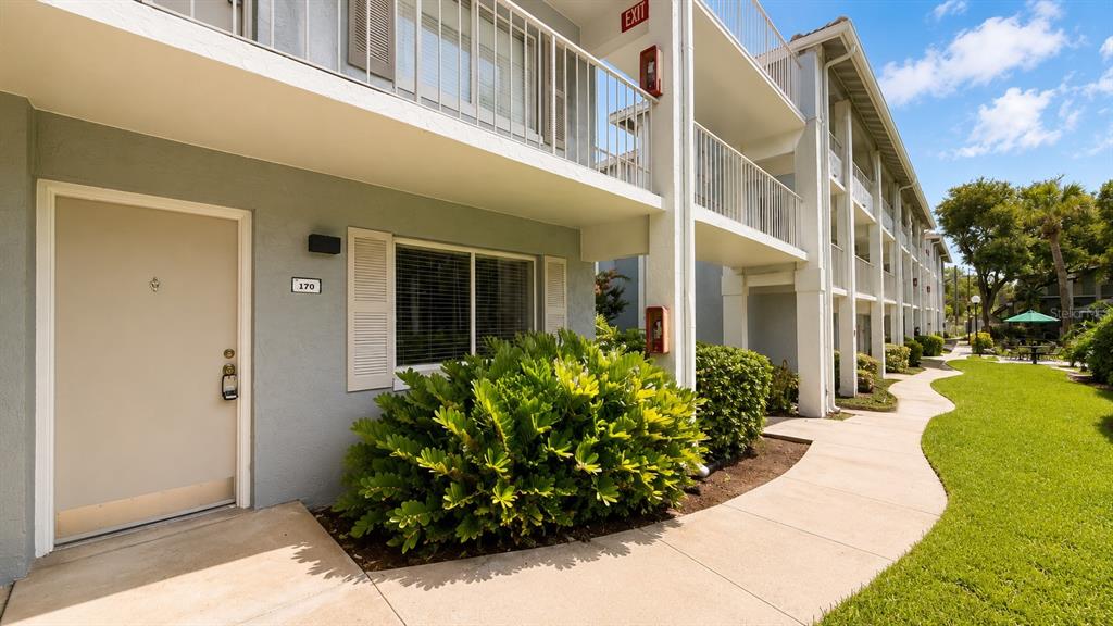 A ground-level apartment entrance with a numbered door, a large bush, and a walkway — 120 BLUE POINT WAY UNIT 170, ALTAMONTE SPRINGS, FL
