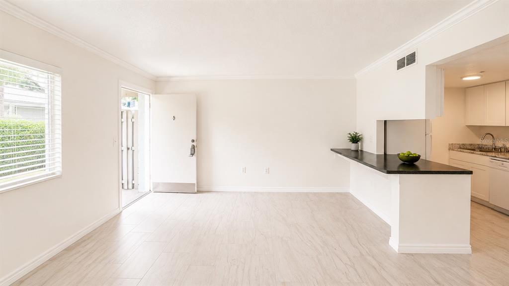 A bright living area with light tile flooring, a breakfast bar, and an open kitchen — 120 BLUE POINT WAY UNIT 170, ALTAMONTE SPRINGS, FL