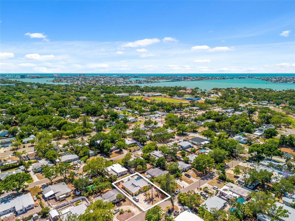 An aerial view shows a residential neighborhood with a highlighted house and a distant bay — 7300 11TH AVENUE N, ST PETERSBURG, FL