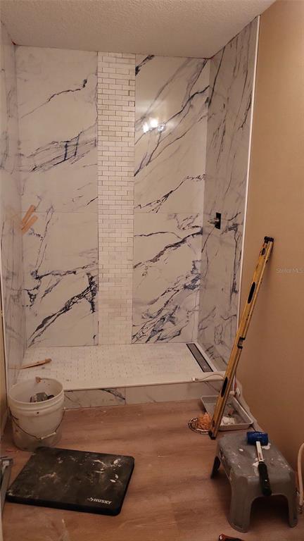 A bathroom shower under construction features large-format marble-look wall tiles and a vertical mosaic accent — 8780 E DERBY OAKS DRIVE, FLORAL CITY, FL