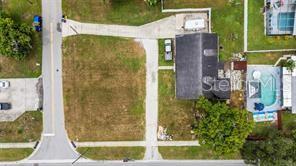 An aerial view shows a vacant lot next to a house with a swimming pool — 2196 BELL CHEER DRIVE, CLEARWATER, FL