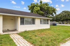 A single-story house with a beige exterior, a dark roof, and a paved walkway — 2196 BELL CHEER DRIVE, CLEARWATER, FL