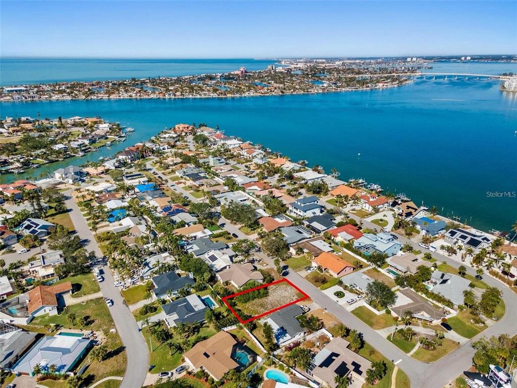 An aerial view shows a vacant rectangular lot outlined in red within a coastal neighborhood — 164 2ND STREET W, ST PETERSBURG, FL