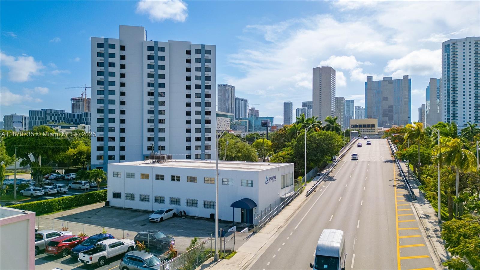 An elevated view shows a white commercial building next to a road and high-rise apartments — 529 W Flagler St, Miami FL 33130, MIAMI, FL