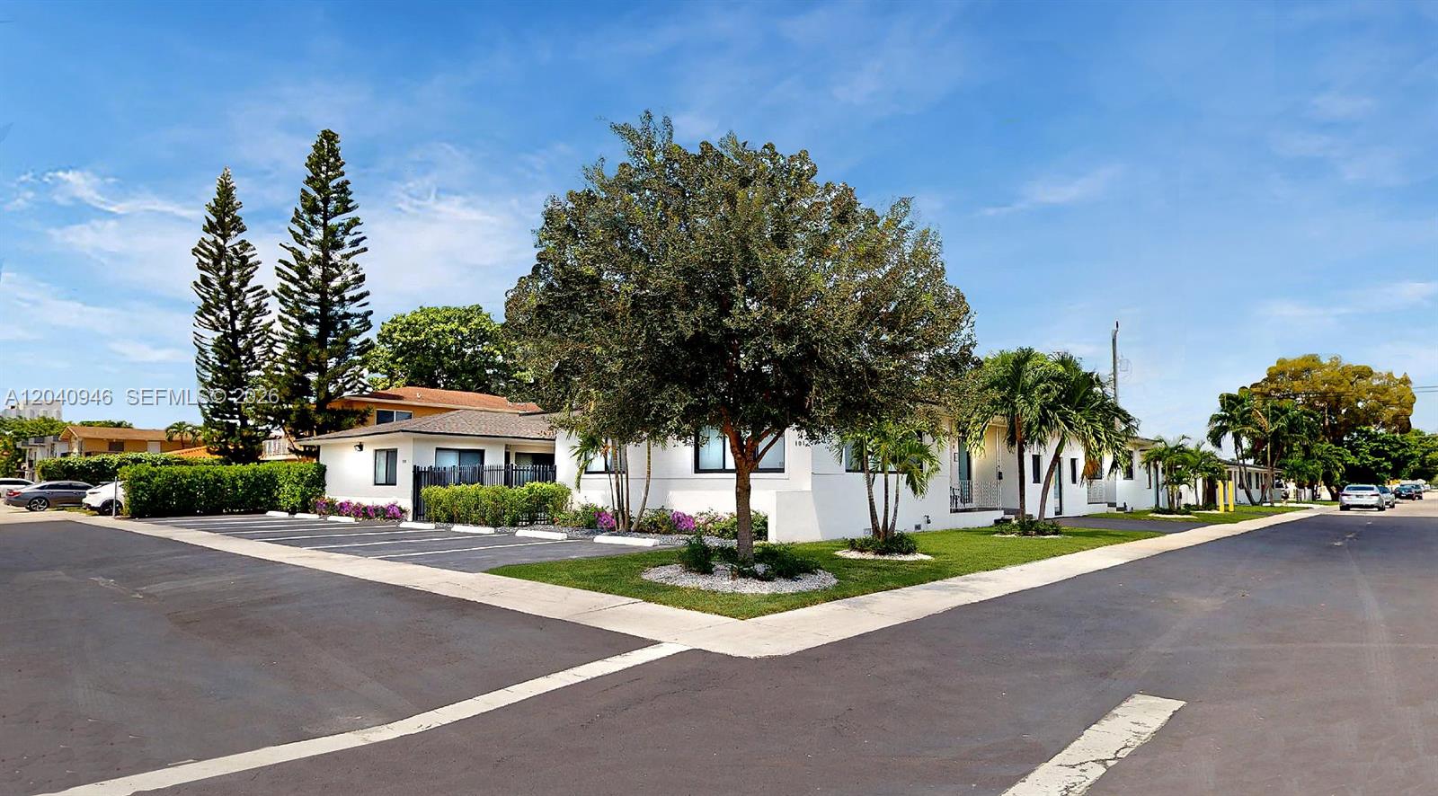 A white single-story building with a parking lot and trees under a blue sky — 101 W 11th St # 4, Hialeah FL 33010, HIALEAH, FL