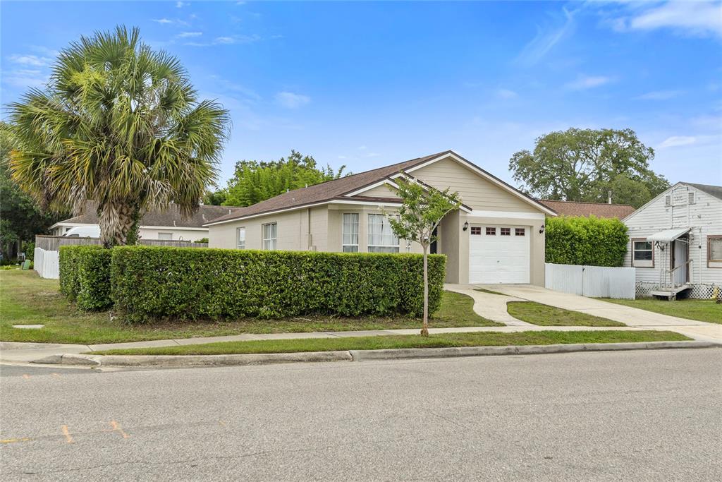 A tan single-story house with a white garage door and a large palm tree — 301 S CAPEN AVE, WINTER PARK, FL