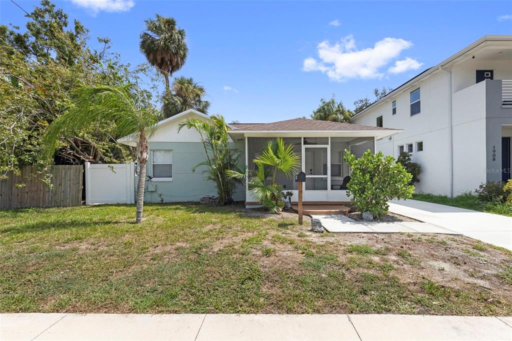 A single-story house with a screened front porch and a palm tree in the yard — 1906 W GRAY STREET, TAMPA, FL
