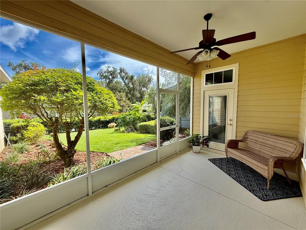 A yellow house with a screened-in porch and attached garage sits behind a grassy yard — 7384 SW 35TH LANE, GAINESVILLE, FL