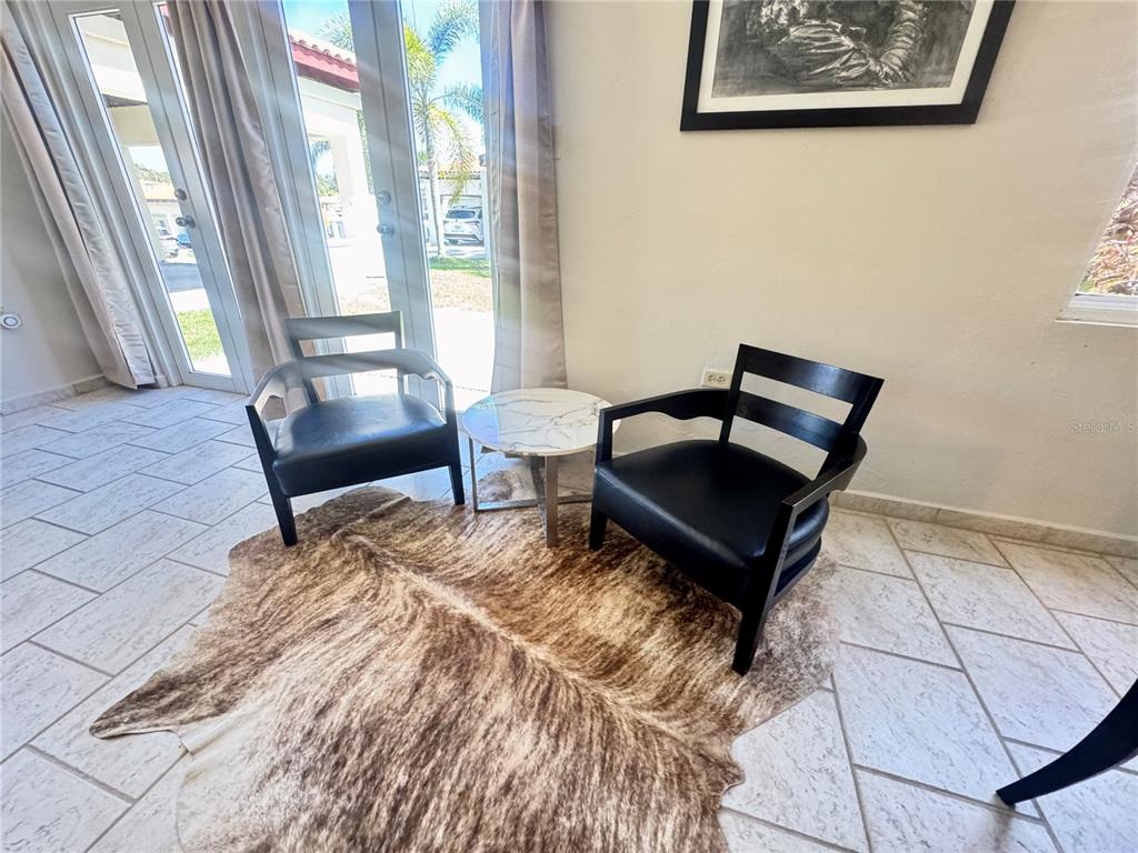 Two black chairs and a small marble table sit on a cowhide rug — C4 AURORA UNIT C-4, HUMACAO, PR