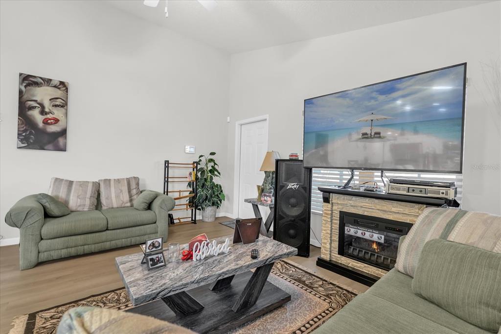 A living room features a green sofa, a marble-topped coffee table, and a large television — 119 D STREET, LAKE WALES, FL