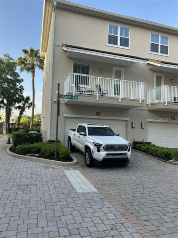 A white pickup truck is parked in front of a multi-story townhouse with a balcony — 641 HANGNEST LANE, LAKE MARY, FL
