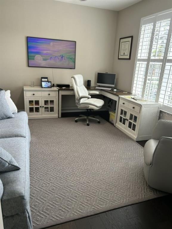 A home office features a desk, white cabinets, a swivel chair, and a patterned area rug — 641 HANGNEST LANE, LAKE MARY, FL