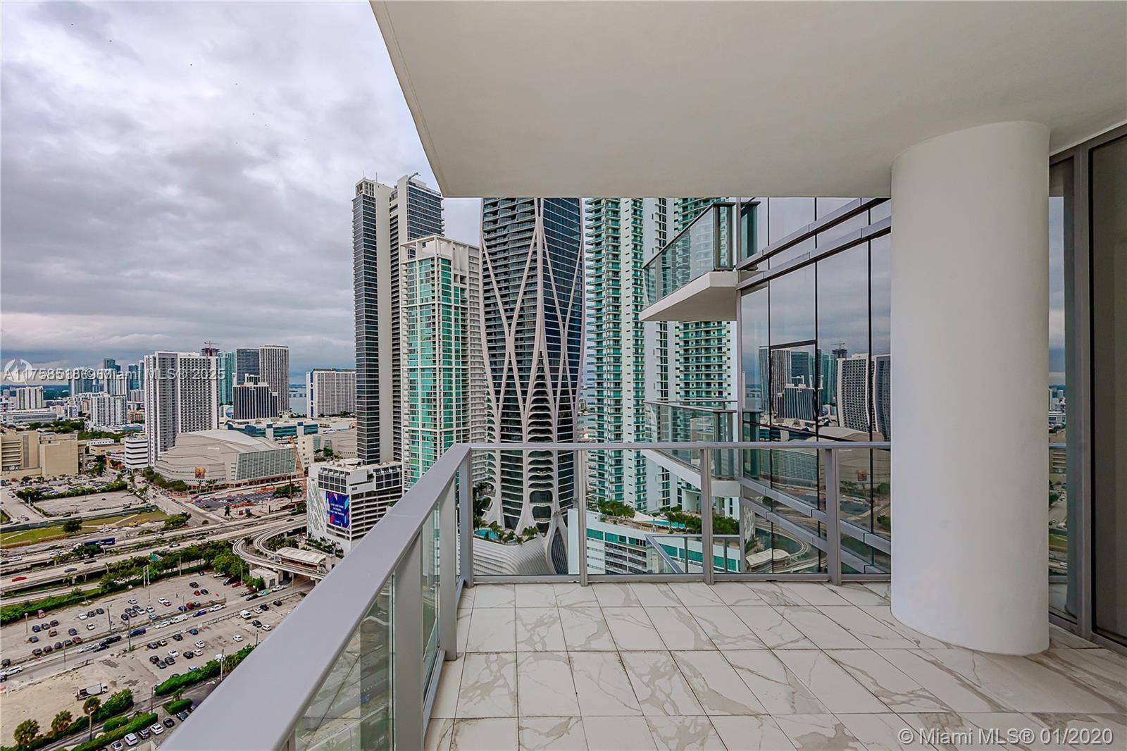 A high-rise balcony with marble-look tile flooring overlooks a dense urban skyline — 851 NE 1st Ave # 2600, Miami FL 33132, MIAMI, FL
