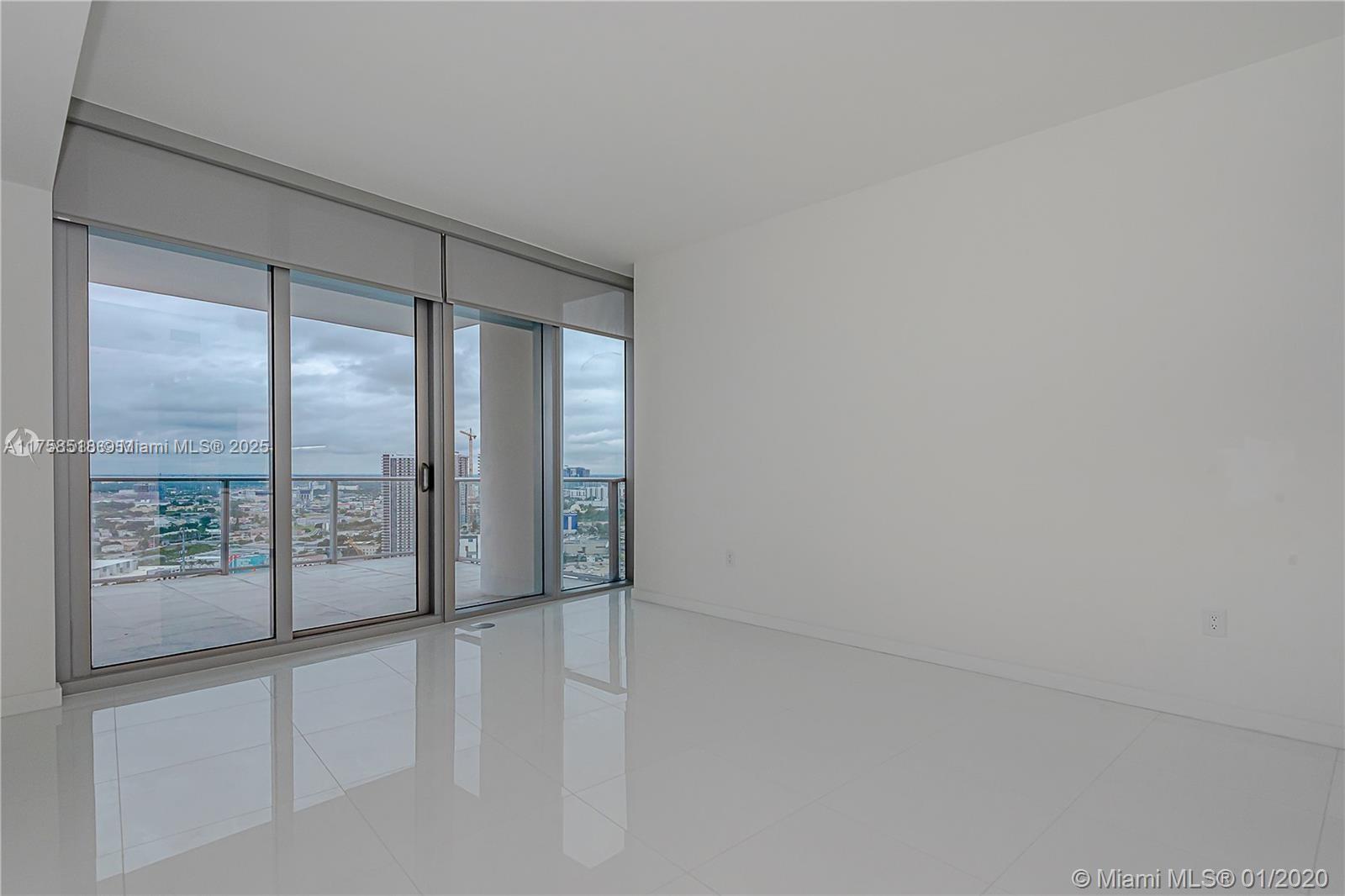 An empty room features white tile floors, white walls, and floor-to-ceiling glass sliding doors — 851 NE 1st Ave # 2600, Miami FL 33132, MIAMI, FL