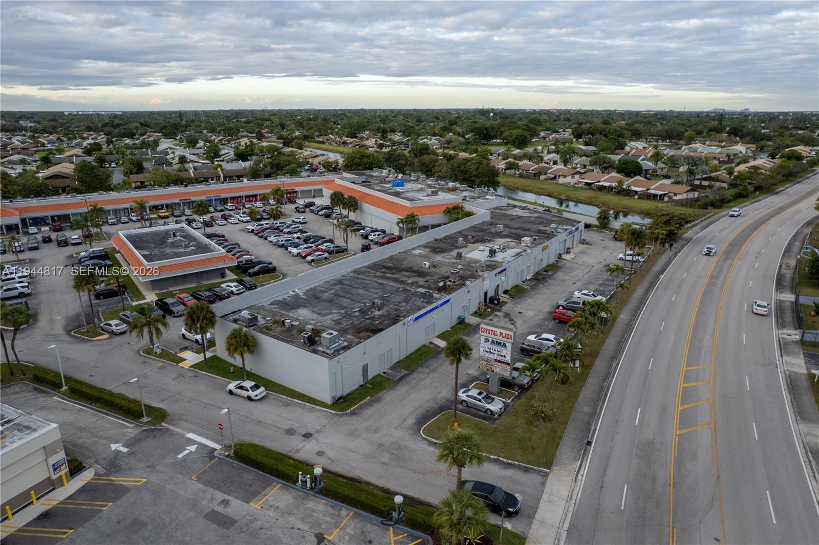 An aerial view shows a commercial strip mall with a parking lot and adjacent road — 12225 SW 112th St, Miami FL 33186, MIAMI, FL