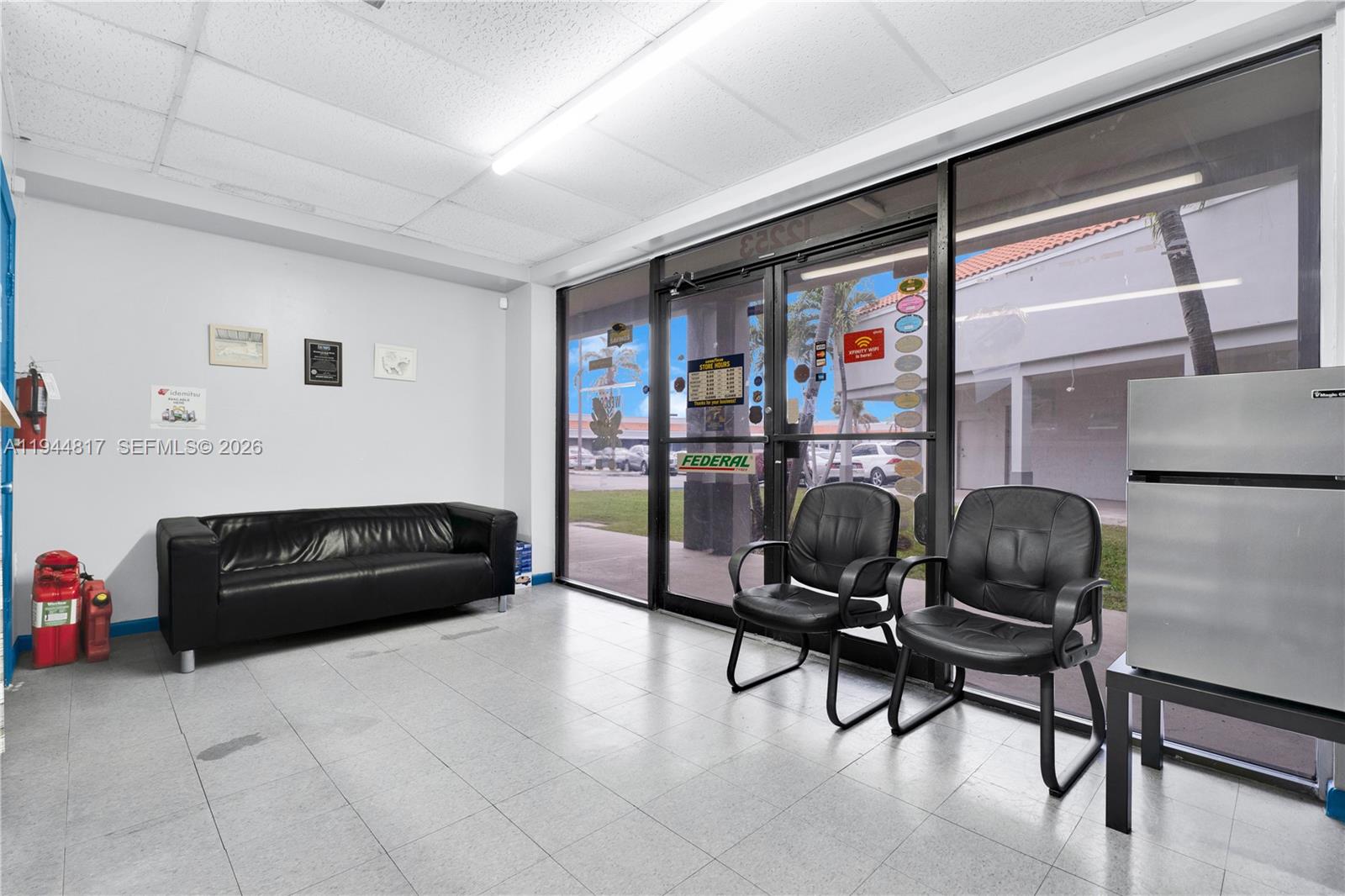A waiting area features a black sofa, two black chairs, and a glass storefront entrance — 12225 SW 112th St, Miami FL 33186, MIAMI, FL
