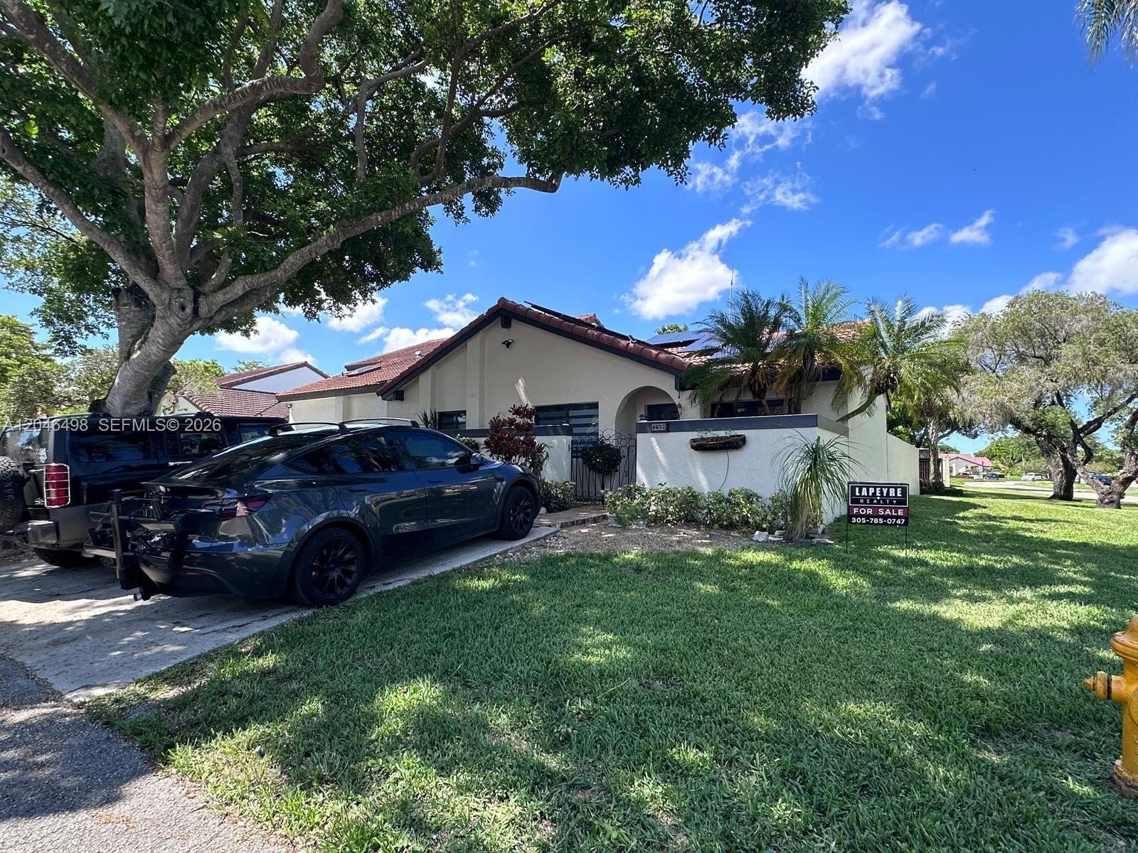 A single-story house with a driveway, a dark car, and a for-sale sign — 6633 NW 178th Ter, Hialeah FL 33015, HIALEAH, FL