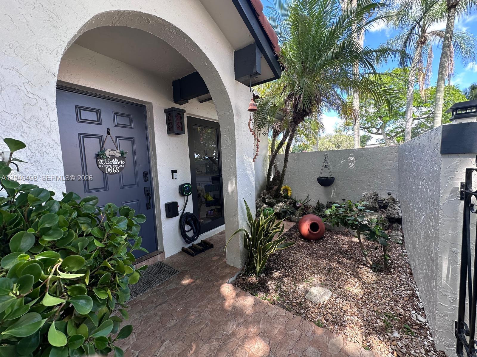 A front entryway features a gray door, a stone-paved patio, and a small rock garden — 6633 NW 178th Ter, Hialeah FL 33015, HIALEAH, FL