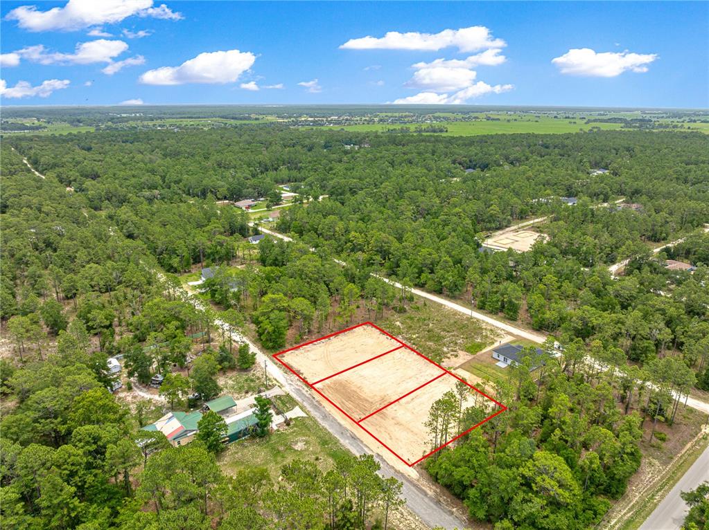 An aerial view shows two adjacent cleared rectangular lots surrounded by dense forest — SW 38TH PLACE, OCALA, FL