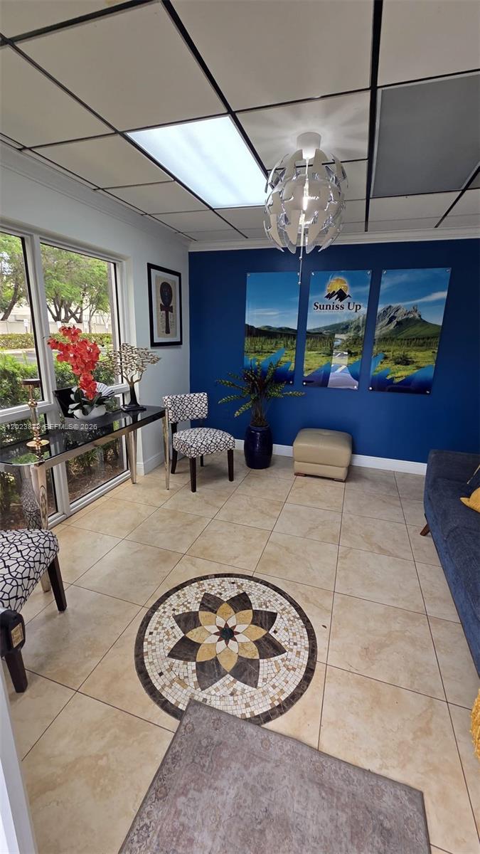 A waiting room features a blue accent wall, tiled floors, and a decorative mosaic medallion — 12001 SW 128th Ct # 101, Miami FL 33186, MIAMI, FL