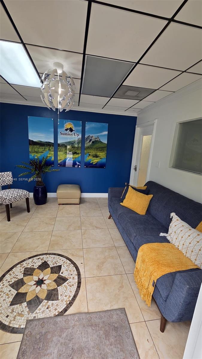 A waiting room features a blue accent wall, a navy sofa, and a mosaic floor inlay — 12001 SW 128th Ct # 101, Miami FL 33186, MIAMI, FL