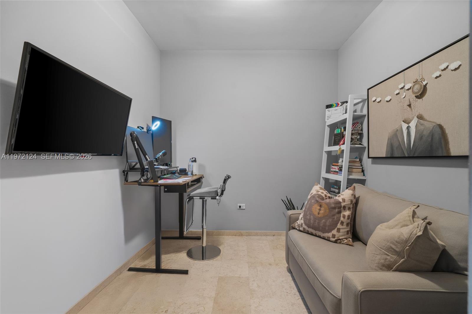 A small home office features a desk, a sofa, a bookshelf, and wall-mounted television — 68 SE 6th St # 3209, Miami FL 33131, MIAMI, FL