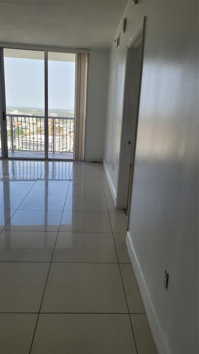 A bright room with white tile flooring leads to a balcony with city views — 1750 N Bayshore Dr # 3311, Miami FL 33132, MIAMI, FL