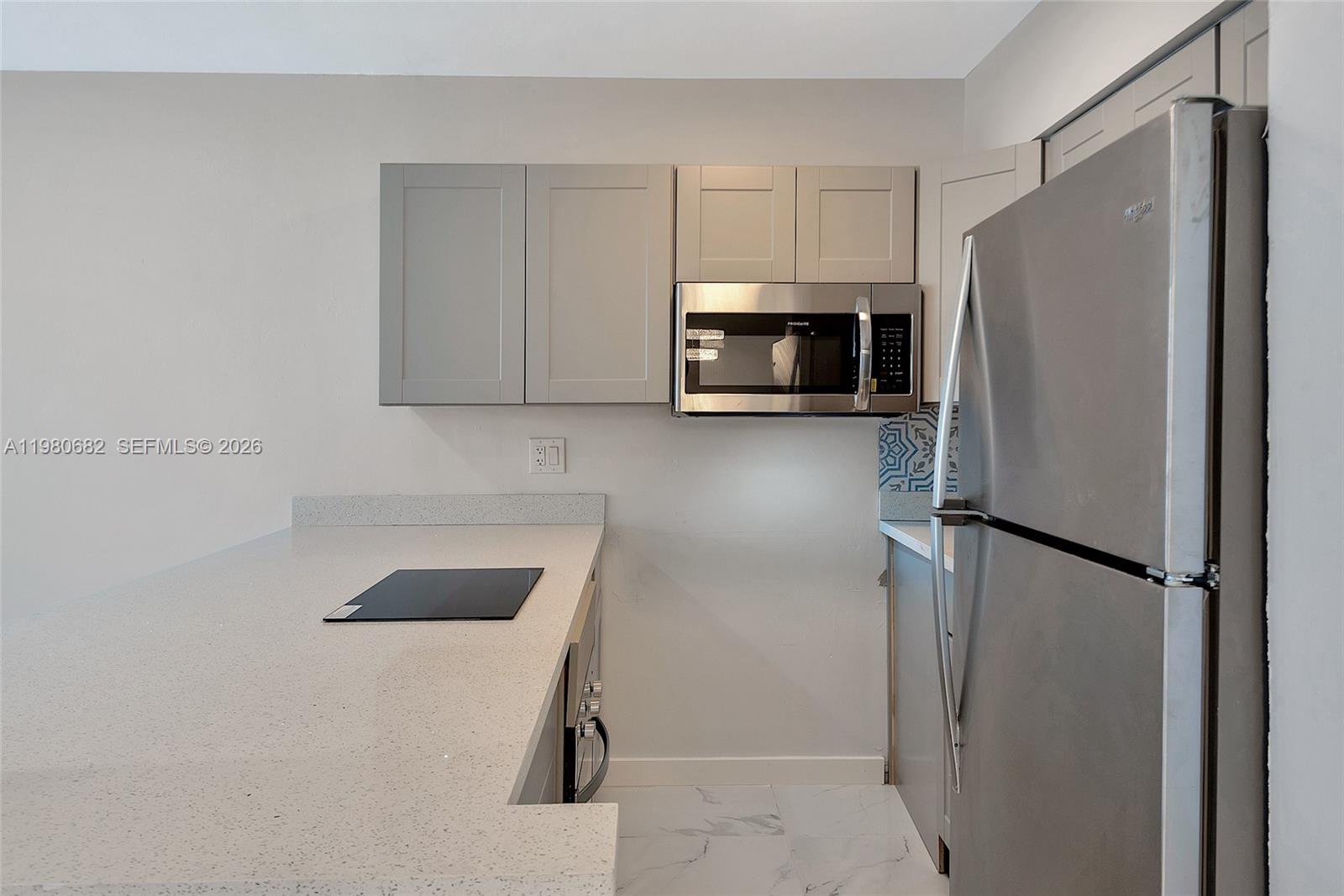 A kitchen features gray cabinets, stainless steel appliances, and white quartz countertops — 820 SW 11th Ave # 14B, Hallandale Beach FL 33009, HALLANDALE BEACH, FL