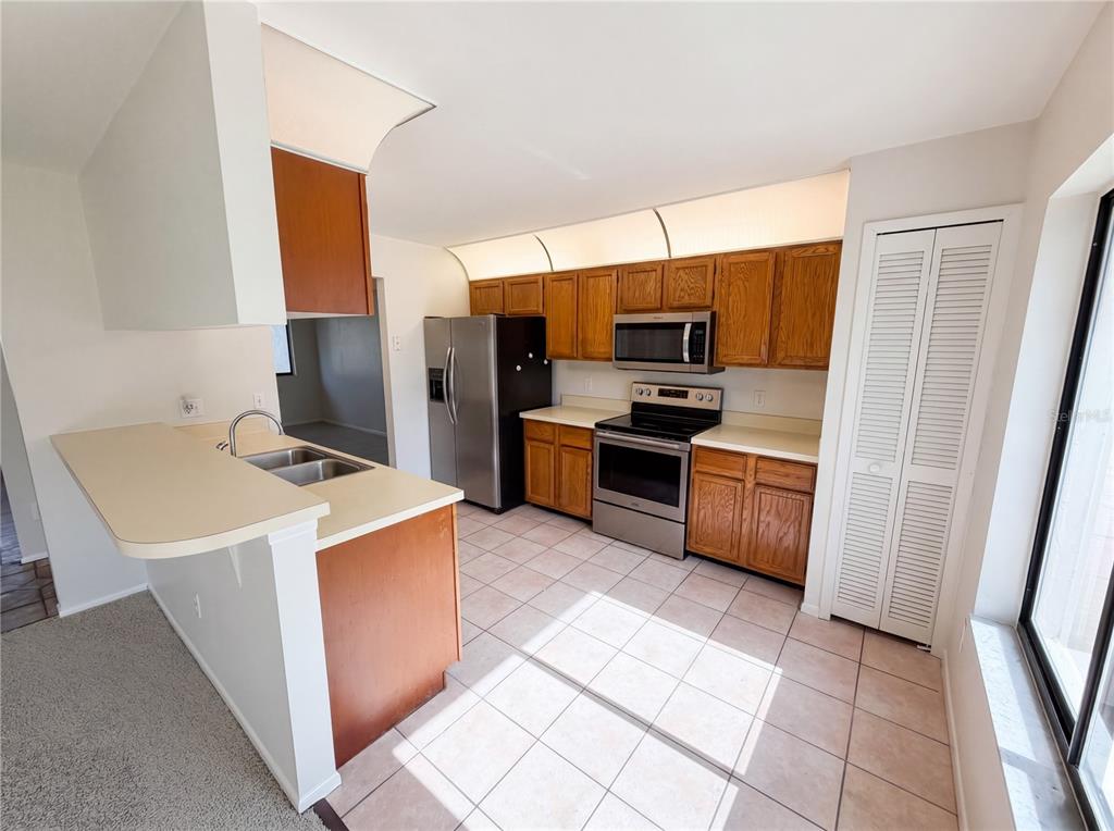 A kitchen features wood cabinets, stainless steel appliances, tile flooring, and a breakfast bar — 2631 ALABASTER AVENUE, ORLANDO, FL