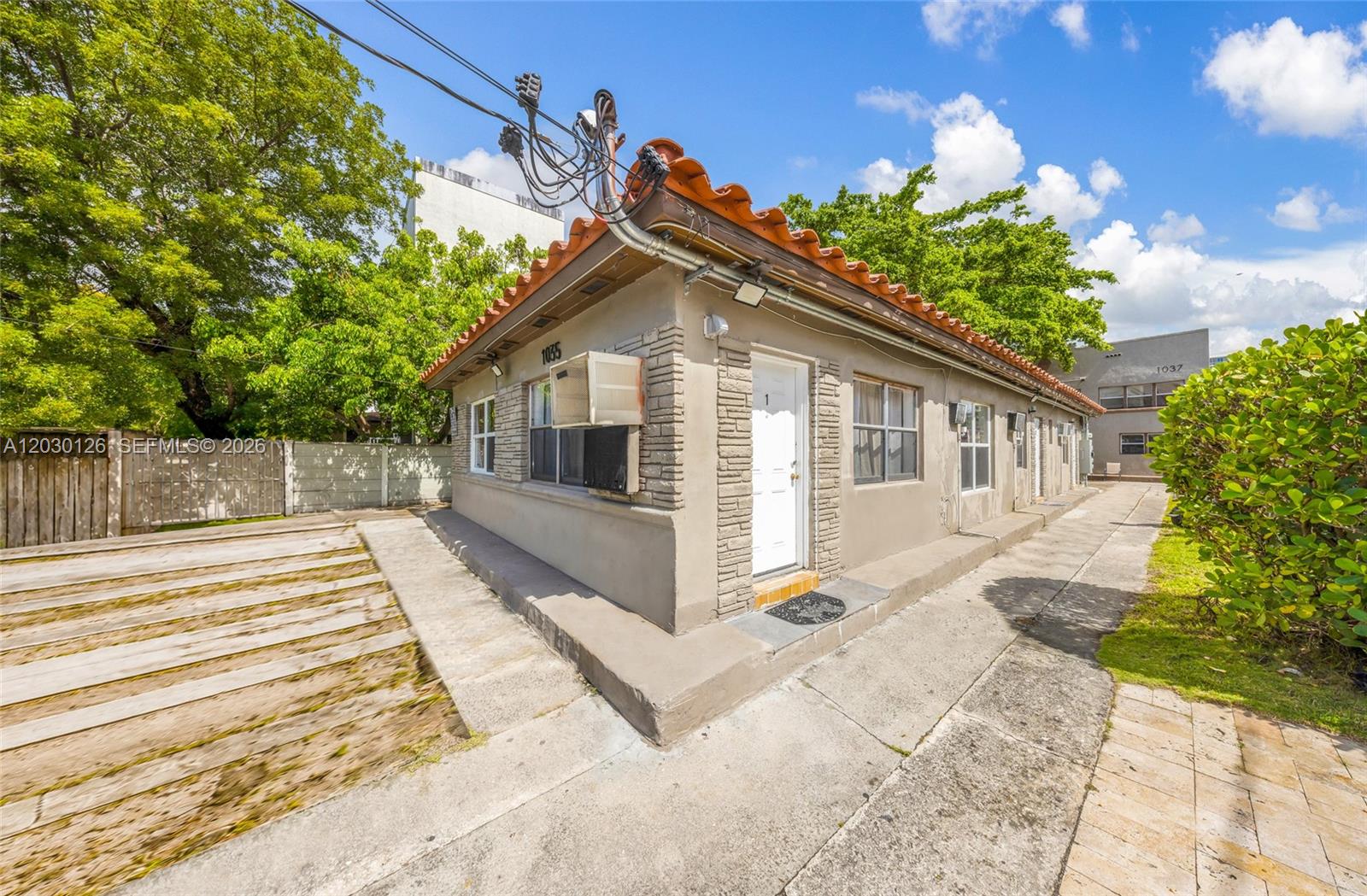 A single-story building with a stucco exterior, tile roof, and a concrete walkway — 1035 NW 4th St, Miami FL 33128, MIAMI, FL