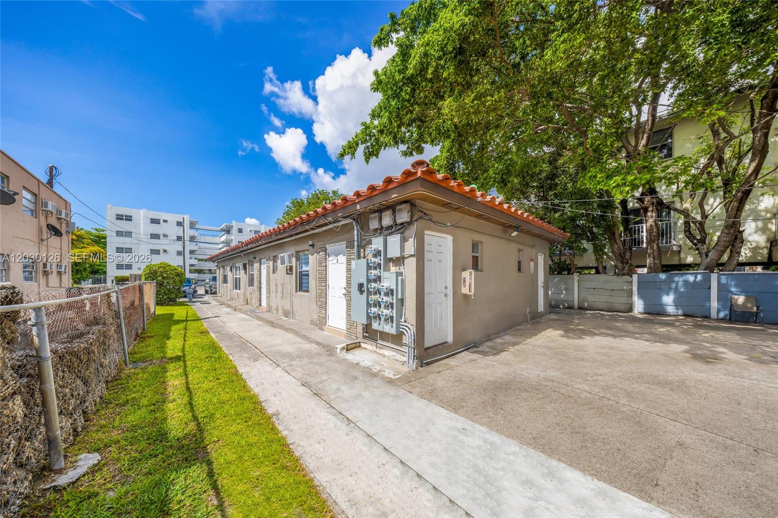 A single-story building with a tiled roof and multiple exterior doors sits on a concrete lot — 1035 NW 4th St, Miami FL 33128, MIAMI, FL