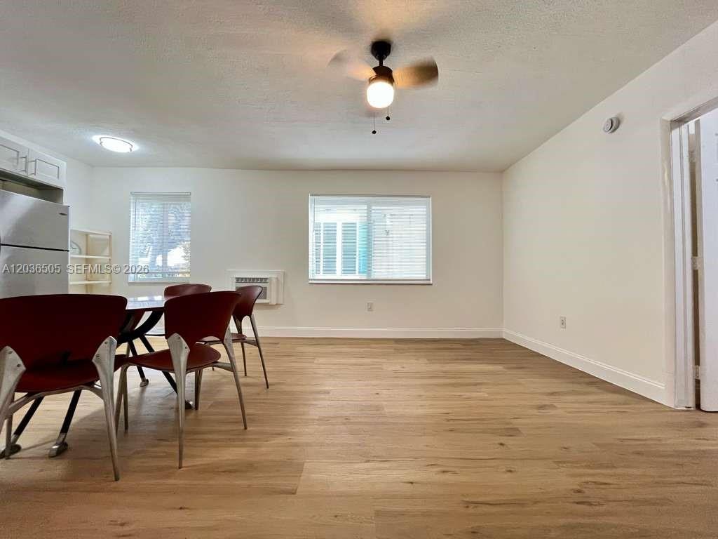 A dining area features light wood-look flooring, a ceiling fan, and a window with blinds — 7928 Harding Ave # 3, Miami Beach FL 33141, MIAMI BEACH, FL