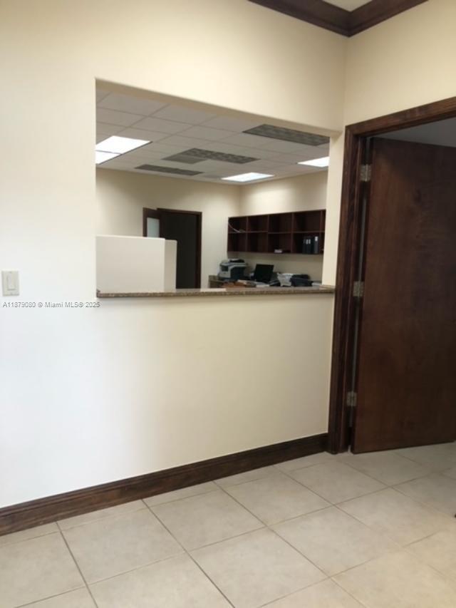 An office interior features a service window opening into a workspace with shelving and desks — 35 Almeria Ave, Coral Gables FL 33134, CORAL GABLES, FL