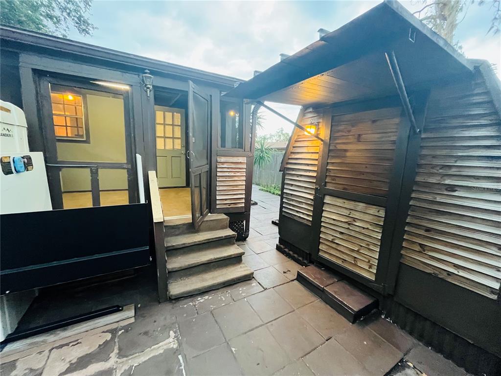 A small wooden structure with a screened porch, exterior stairs, and a slatted storage shed — 5325 LIME AVENUE, SEFFNER, FL