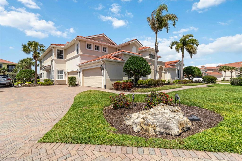 A two-story stucco house with a tile roof, a two-car garage, and a paved driveway — 133 BELLA VISTA TERRACE UNIT 32C, NORTH VENICE, FL